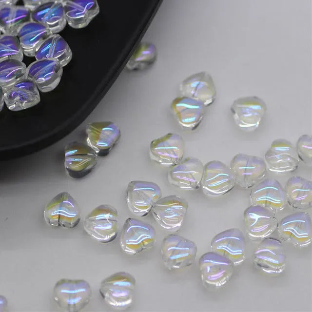 20 heart-patterned Czech beads in aurora colours including purple, blue rose, and white
