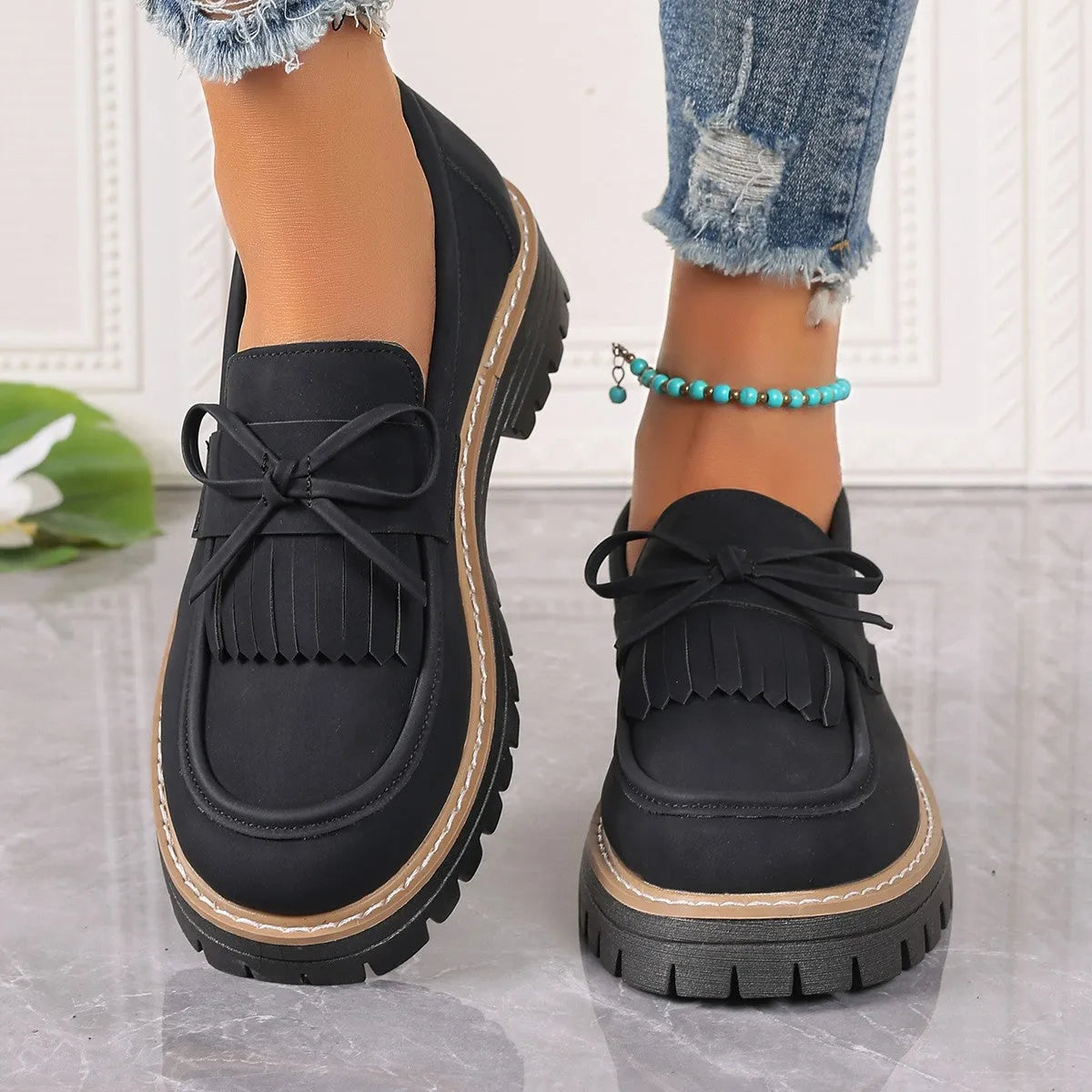 Black plus size women's loafers with a tassel and bowknot on a round toe, low top design.
