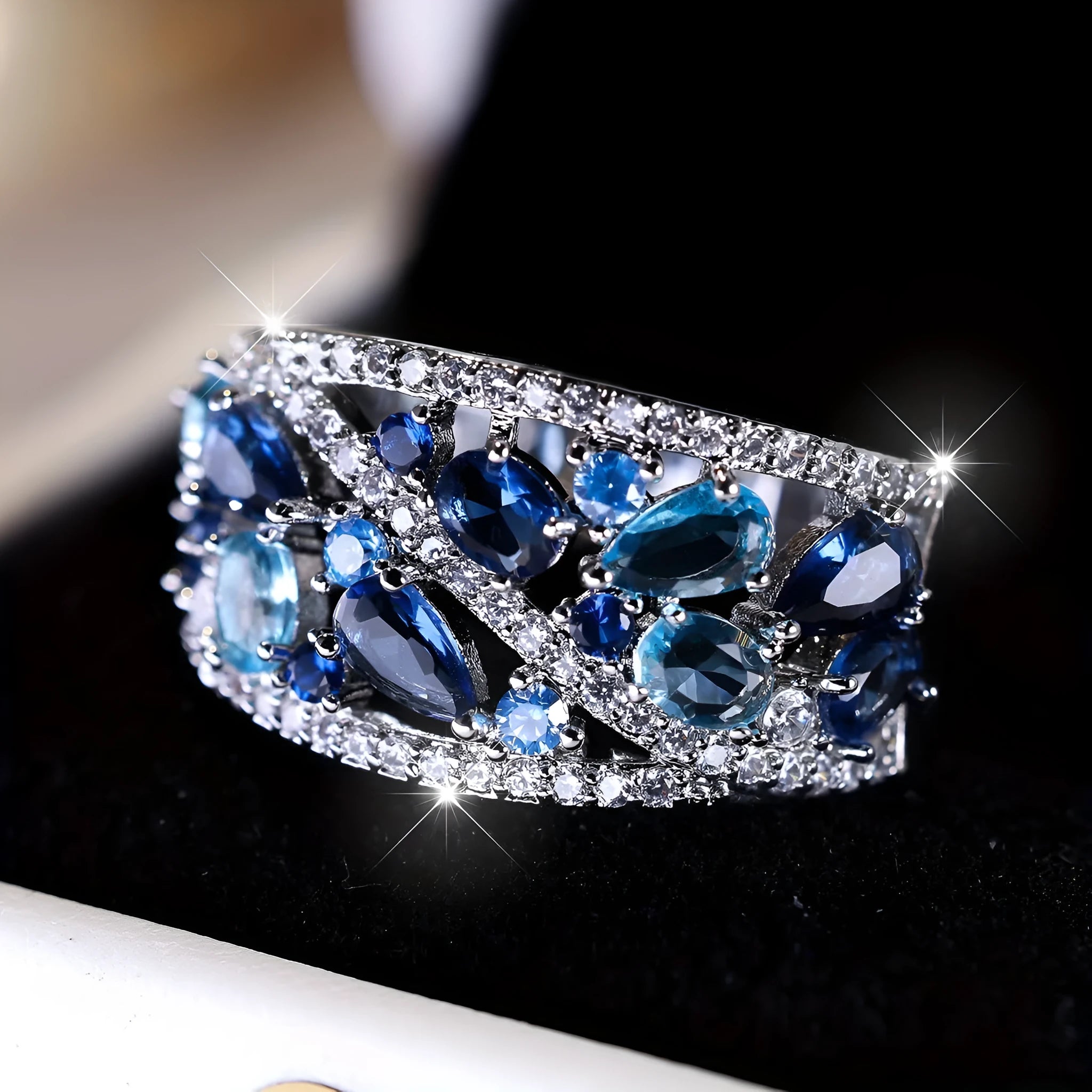Women's round hollow fashion ring in gold or platinum with a diamond or blue sapphire stone.