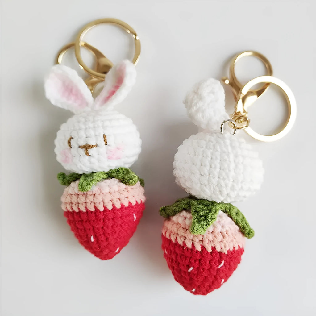 White hand-woven wire pendant with cartoon rabbit and strawberry design, shown with an integrated key.