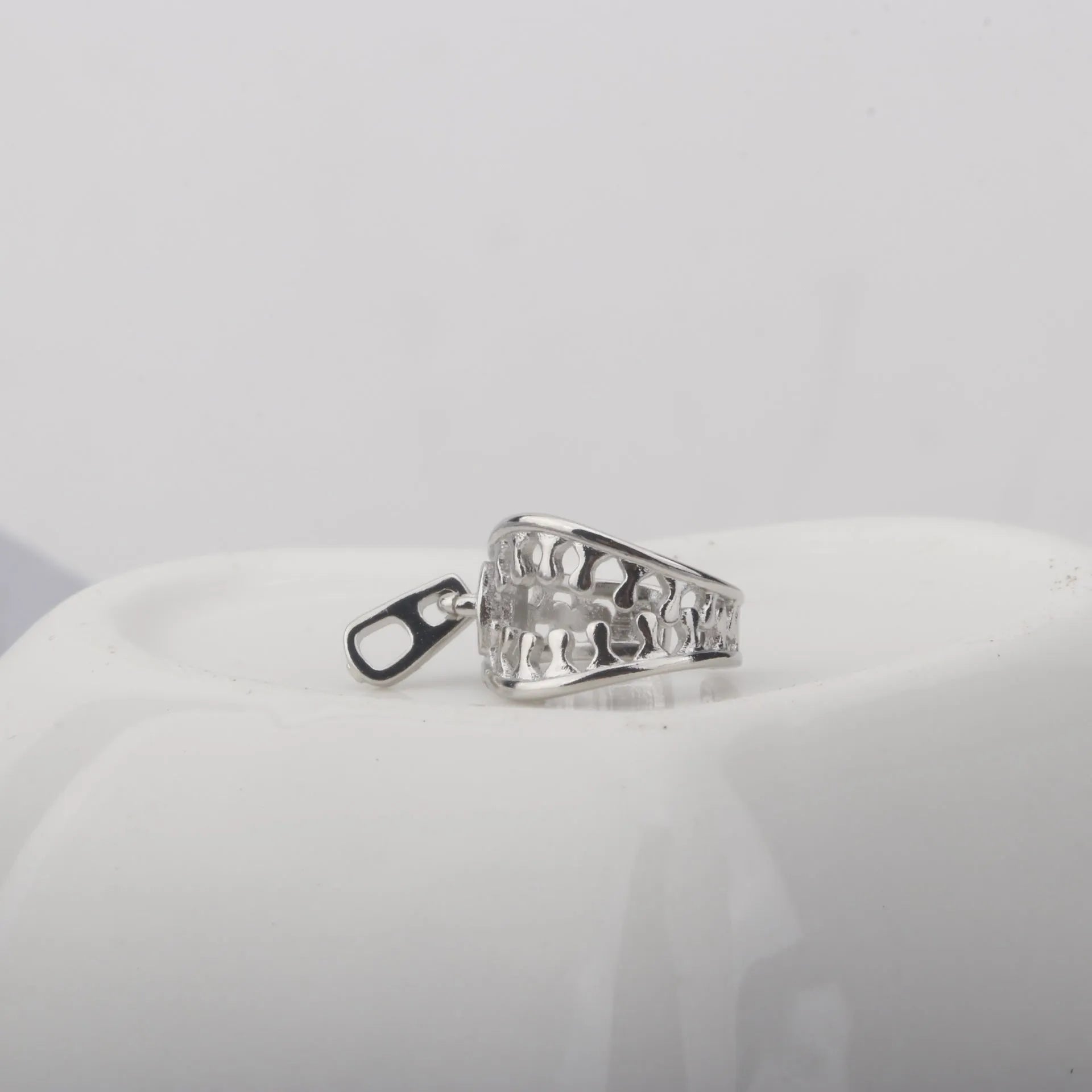 A pair of geometric copper clip-on earrings with linear design details and a zipper ear clip fastening.
