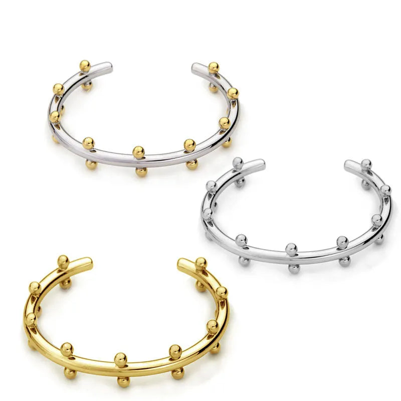 Stainless steel C-shaped bean bead bracelet with textured rivet design in gold and steel colours
