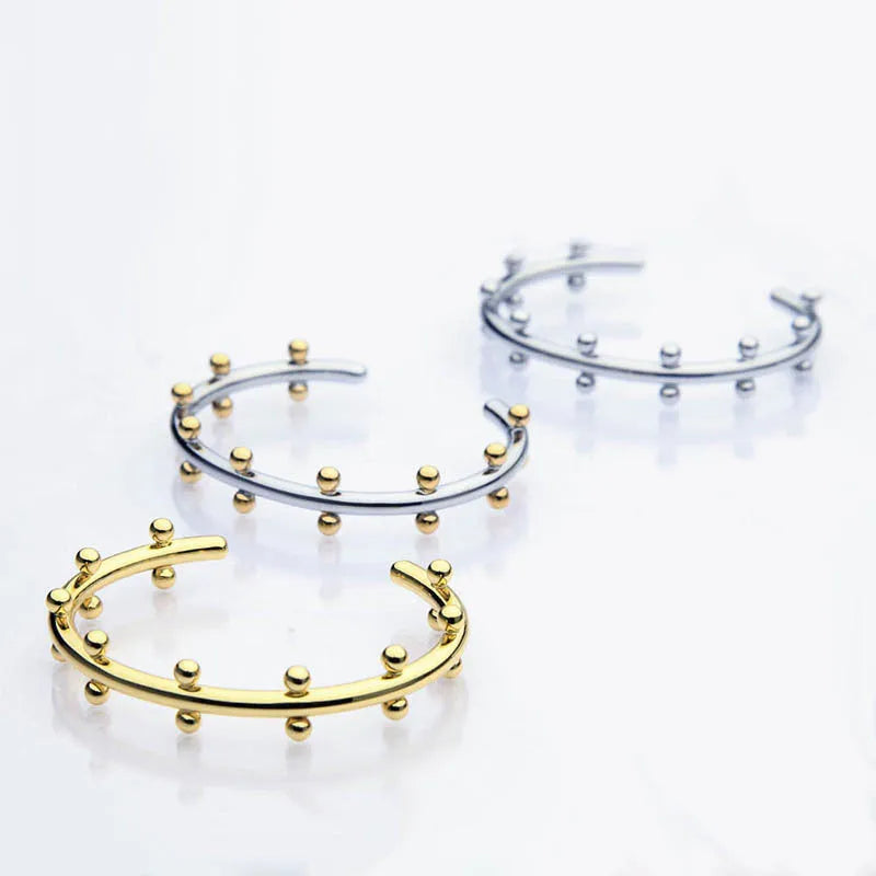 Stainless steel C-shaped bean bead bracelet with textured rivet design in gold and steel colours