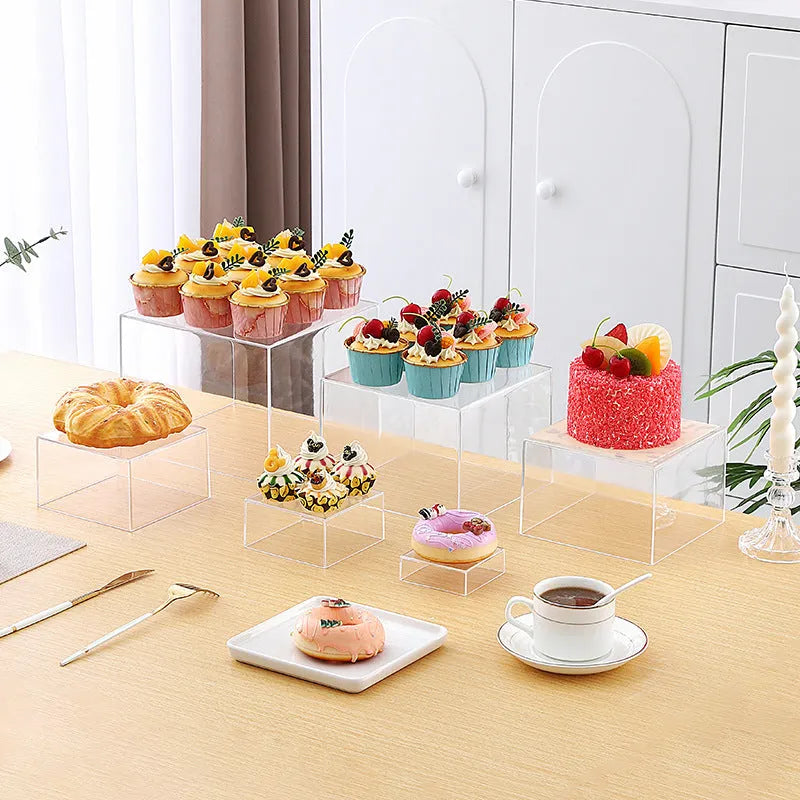 White plastic modular dessert display stand with six stackable suit cube racks on a table.