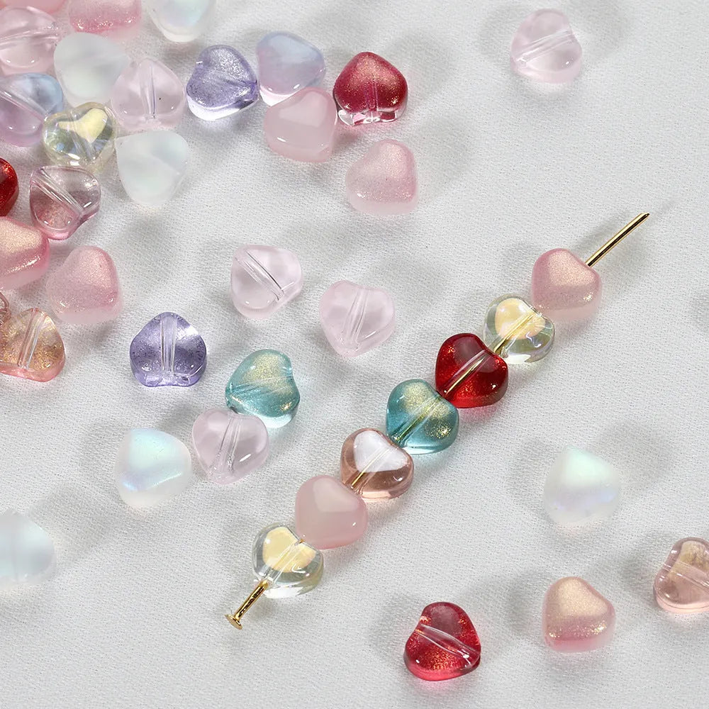 20 heart-patterned Czech beads in aurora colours including purple, blue rose, and white