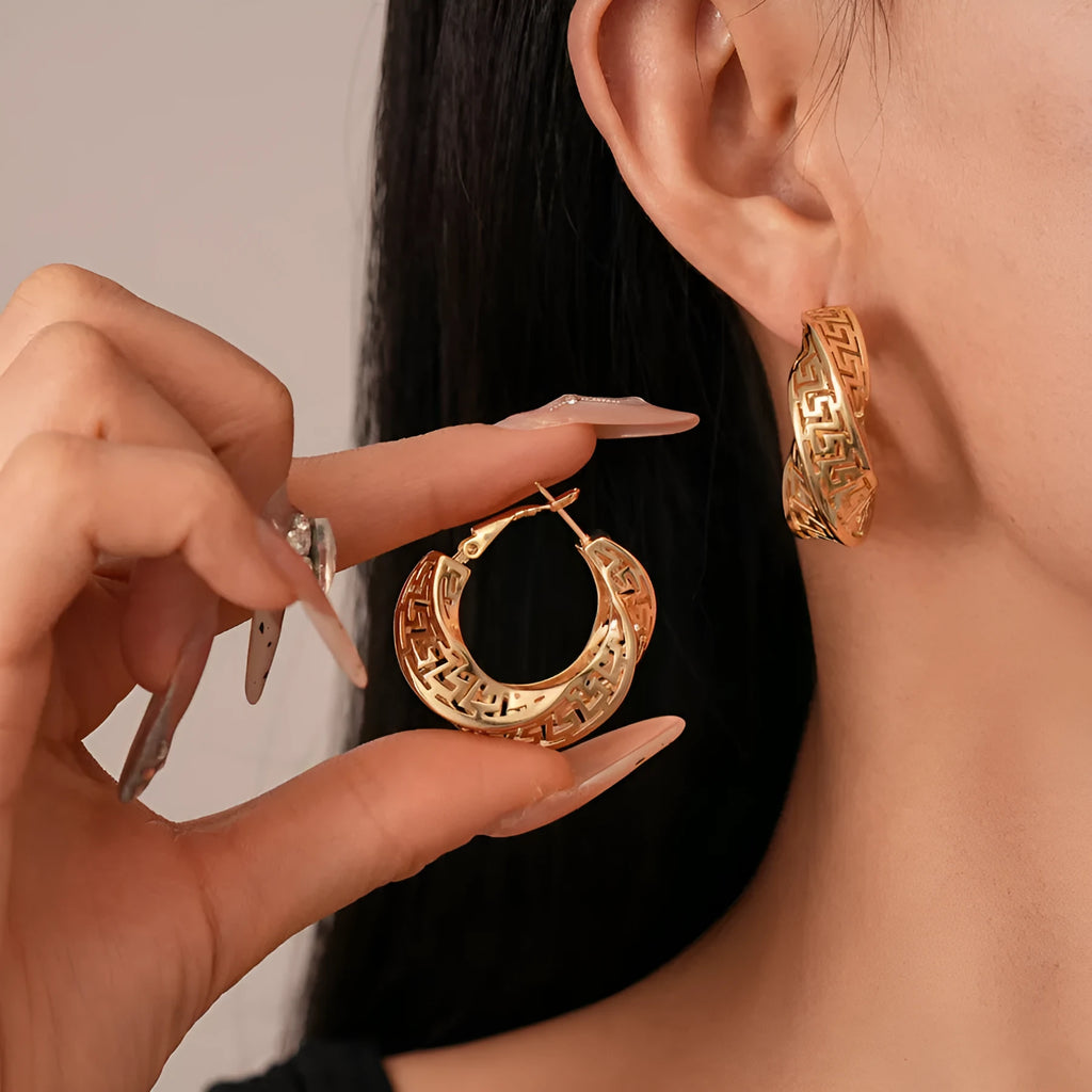 Twisted geometric hollow stud earrings in gold or silver finish with exaggerated round design