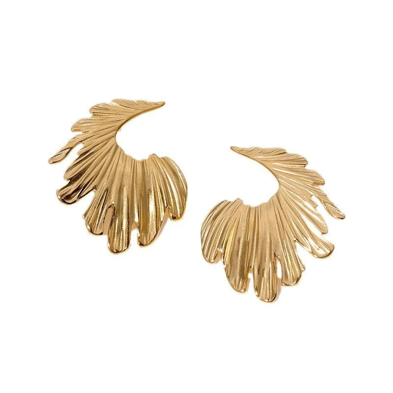 Close-up of a pair of stainless steel leaf-shaped stud earrings on a gold or steel-coloured background.