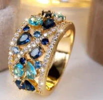 Women's round hollow fashion ring in gold or platinum with a diamond or blue sapphire stone.
