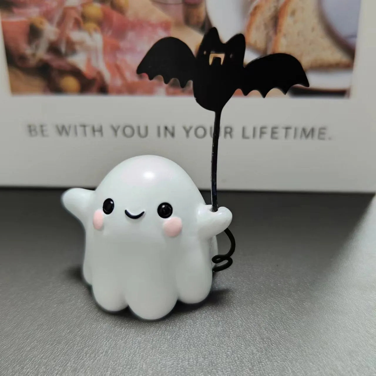 Small resin ghost walking dog statue with a bat, a Halloween decoration.
