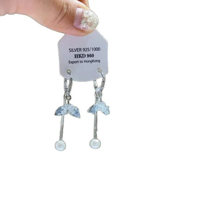 Close-up of a women's geometric alloy ear clip with rhinestones, a star charm, and a tassel on a white background.