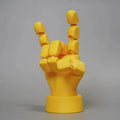Yellow articulated PLA hand prop with movable fingers on a neutral background.