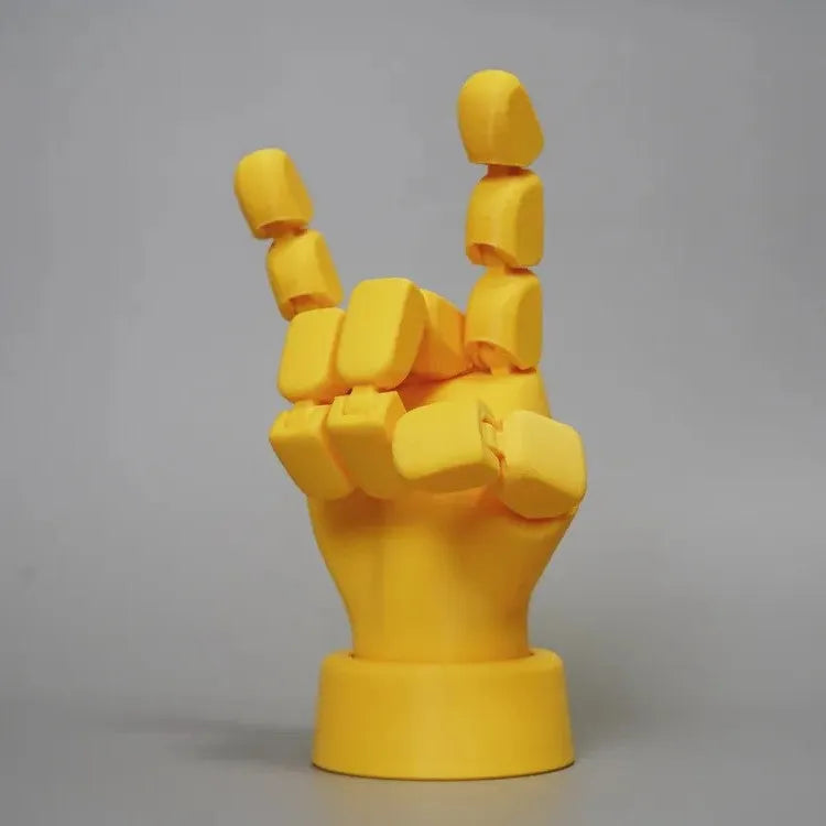 Yellow articulated PLA hand prop with movable fingers on a neutral background.