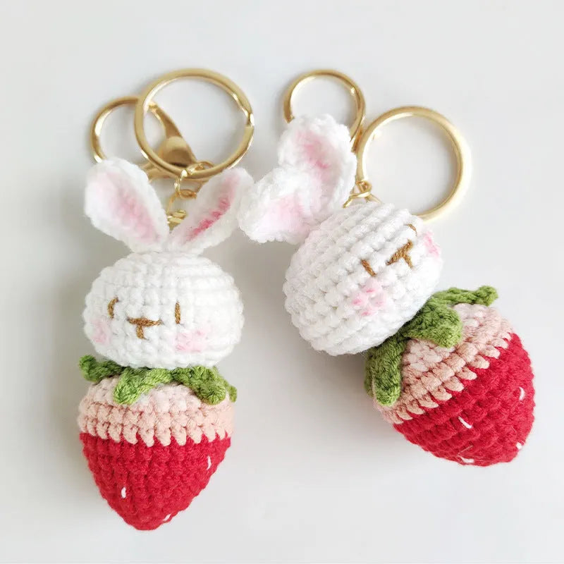 White hand-woven wire pendant with cartoon rabbit and strawberry design, shown with an integrated key.