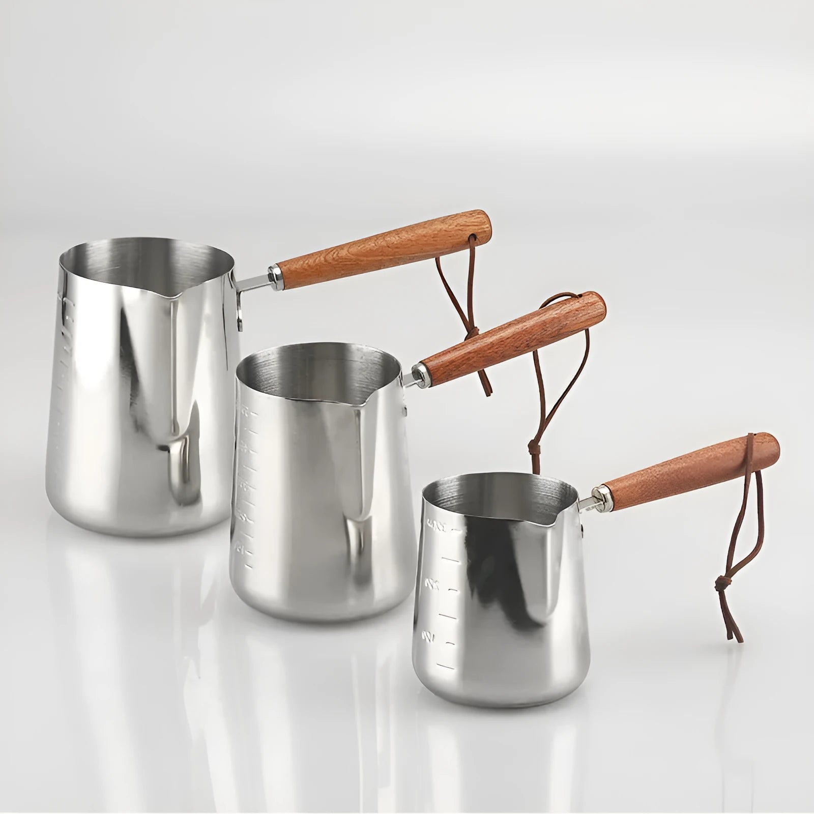 Stainless steel measuring milk cup with wooden handle showing scale markings.