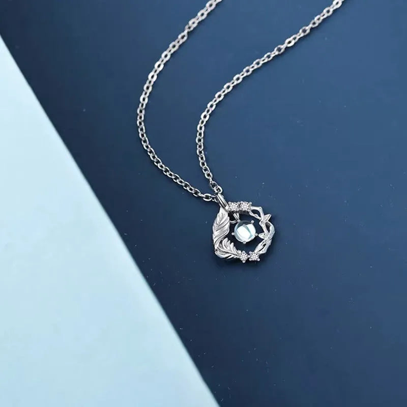 Geometric alloy pendant necklace showing a tree and bird silhouette on an adjustable chain.
