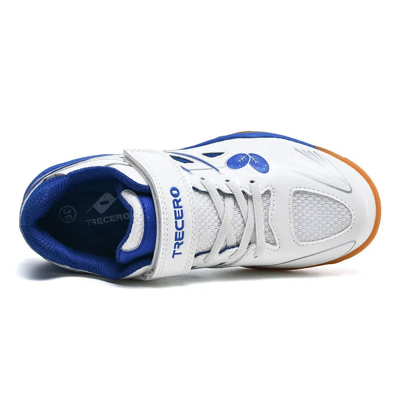White and blue lightweight badminton shoes with a ribbed non-slip sole, shown on a court surface.