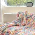 Handmade thick chenille striped blanket in caramel mango colour on a bed