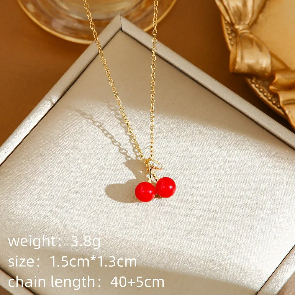 Titanium steel delicate necklace with indie cherry, strawberry, and pepper charms on an O-ring chain, shown in golden and steel colour variations.