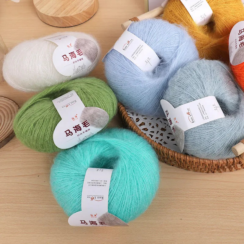 A ball of mohair yarn for a hand-woven DIY scarf kit, shown with a selection of its 34 colour options.