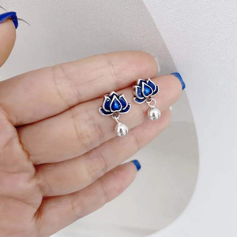 Blue alloy lotus flower ear studs with a seedpod tassel on silver posts.