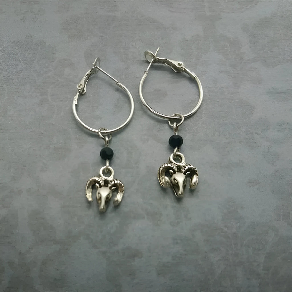 Silver alloy round hoop earrings with a Tibetan antelope design detail.