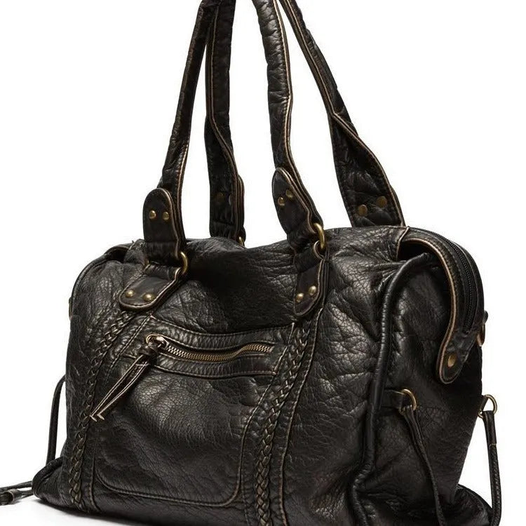 Women's European retro motorcycle messenger bag in bright black with golden edge showing weaving details and shoulder strap