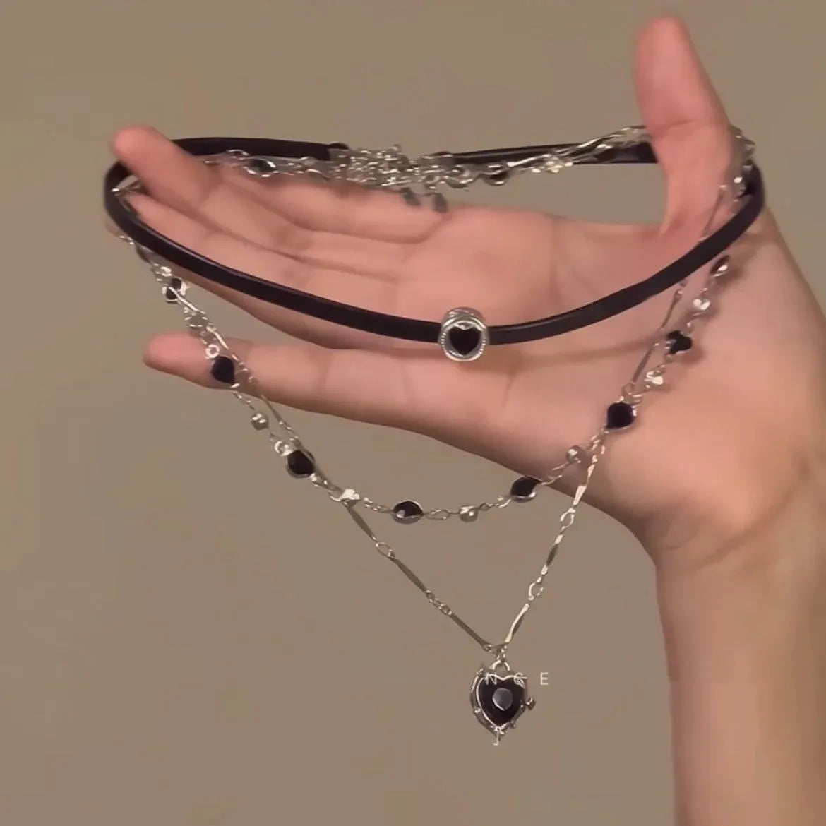 Women's creative double-layer necklace with heart-shaped crystal pendant and leather accents on an adjustable chain.