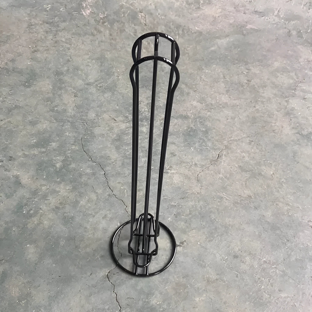 Black wrought iron coffee capsule storage rack displaying pods on a kitchen worktop.