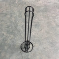 Black wrought iron coffee capsule storage rack displaying pods on a kitchen worktop.