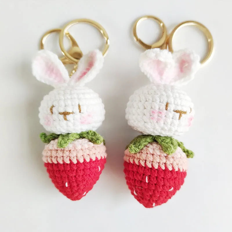 White hand-woven wire pendant with cartoon rabbit and strawberry design, shown with an integrated key.