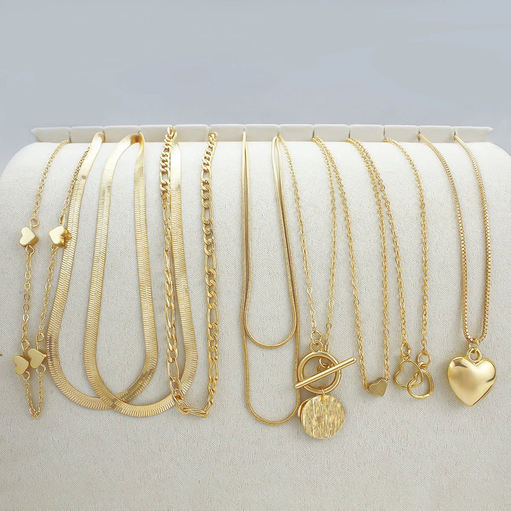 Set of ten gold electroplated women's necklaces with snake bone chains and alloy pendants.