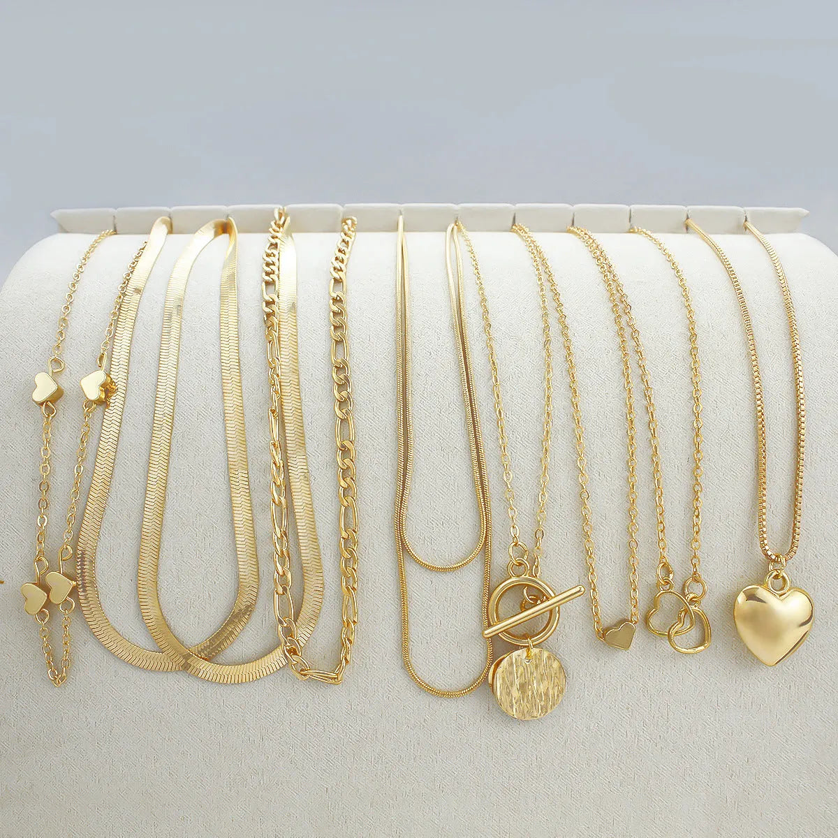 Set of ten gold electroplated women's necklaces with snake bone chains and alloy pendants.