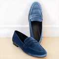 Blue suede-style women's loafers with a black rubber sole, shown in a flat profile.