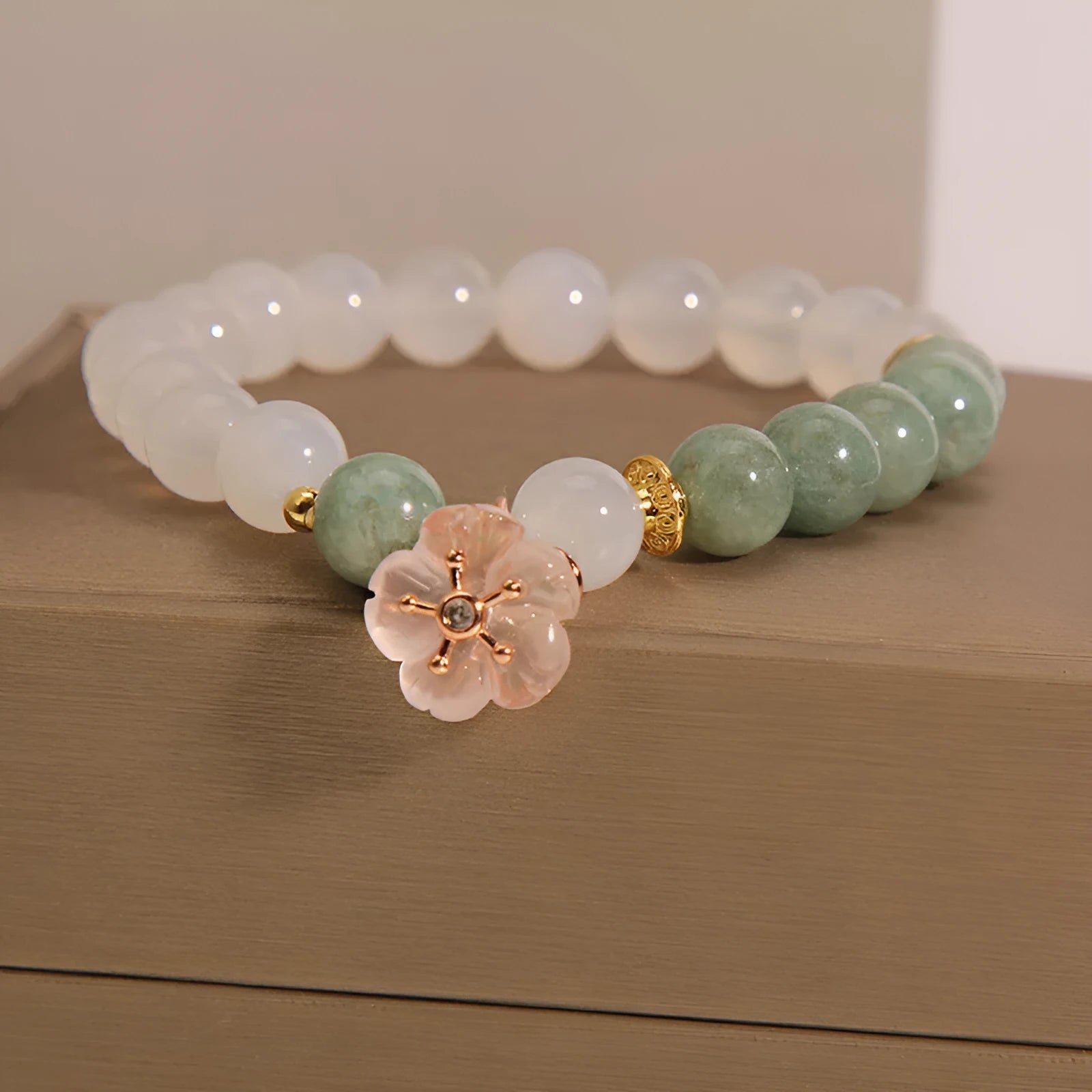 Jade floral bracelet with white agate jadeite stone and pink flower details on wrist