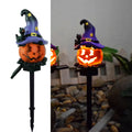 Solar Halloween pumpkin lantern with wizard pumpkin style on a garden path, wrought iron frame
