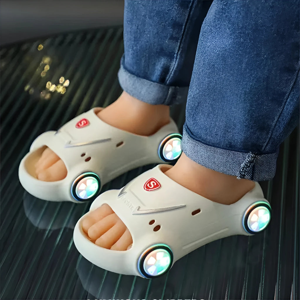 Children's luminous cartoon car slippers with anti-slip soles in blue, black, white, yellow, and pink colours.