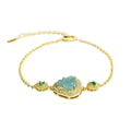 Close-up of a blue jade Maitreya Buddha pendant on a women's bracelet.