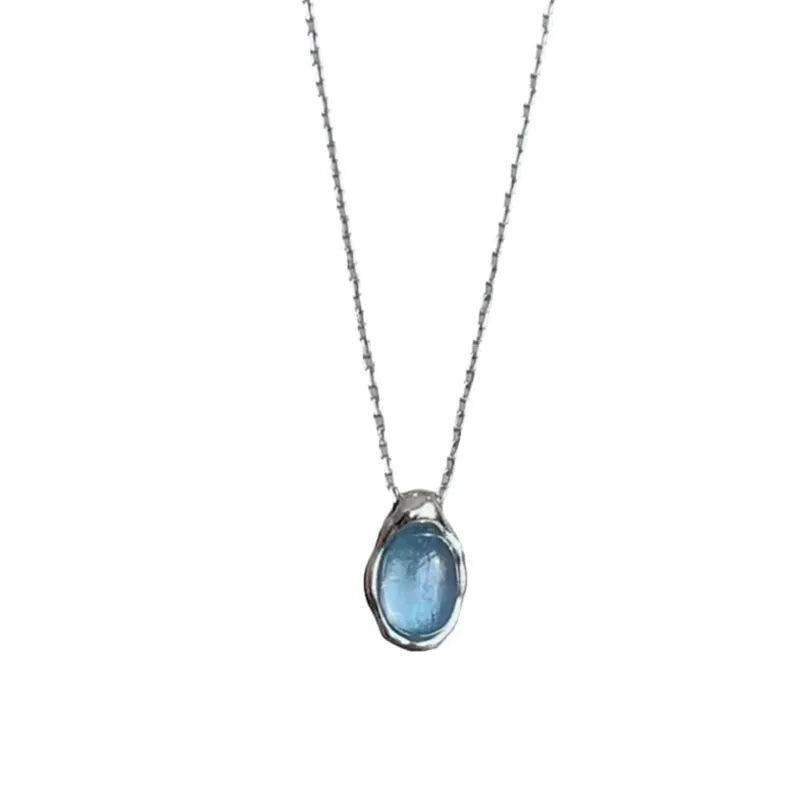 Geometric navy blue water drop pendant on an adjustable platinum-colour cross chain necklace.