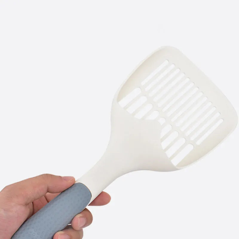 Large white plastic cat litter shovel with angled handle on a grey background.