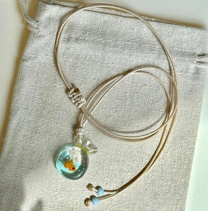 Women's necklace with coloured glaze joker charm on a cotton and linen clavicle chain