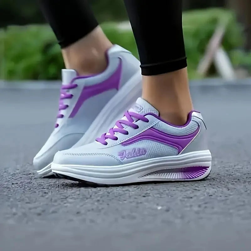 Women's grey and black casual sports shoes with a medium heel on a plain background