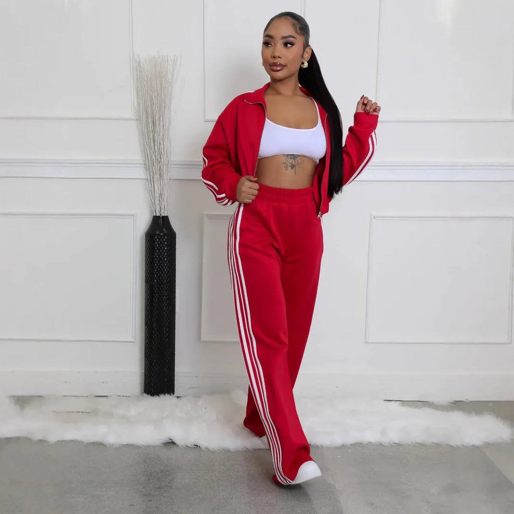 A striped grey two-piece tracksuit set with a zipper top and trousers on a mannequin.