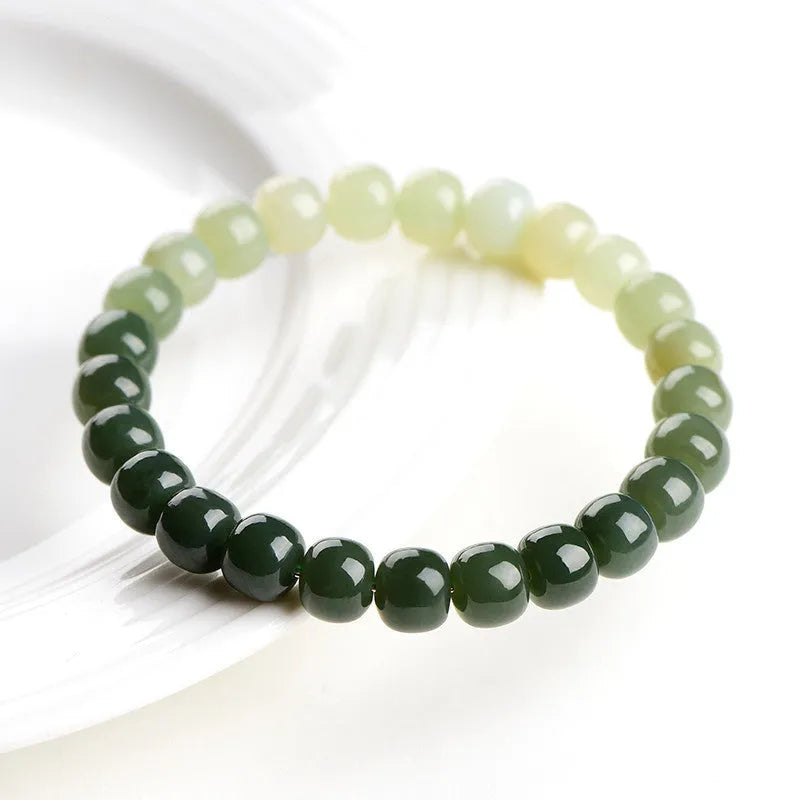 Natural Hetian jade bracelet with gradient clear water colours on a wrist, showing polished beads.