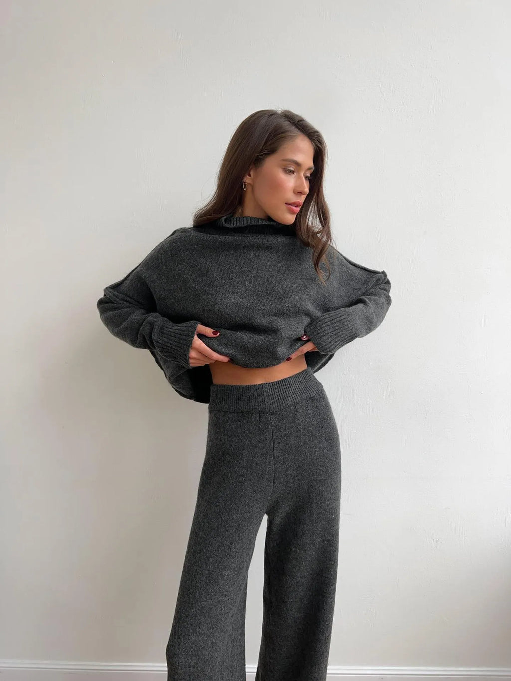 Women's solid colour acrylic sweater and trousers suit set with a side-slit top design.