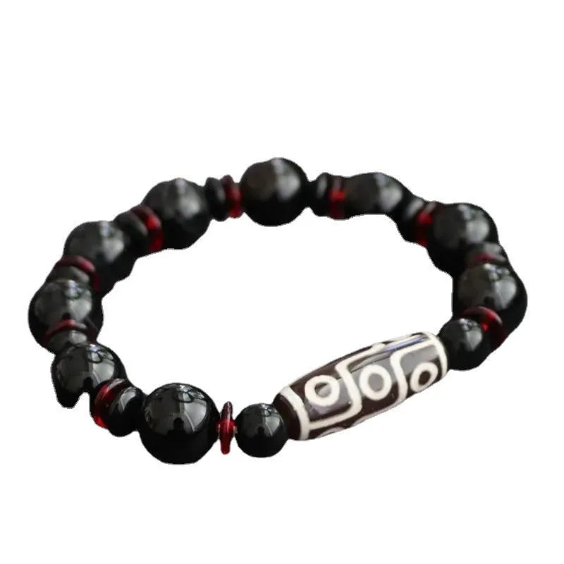 Black agate dzi bead bracelet with hand-woven geometry beads on a wrist.