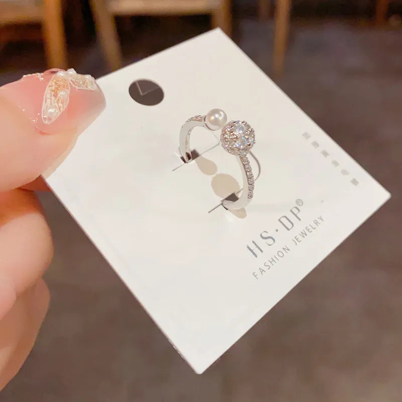 A simple geometric open-end ring with a round zircon stone, shown in gold and silver plated finishes.