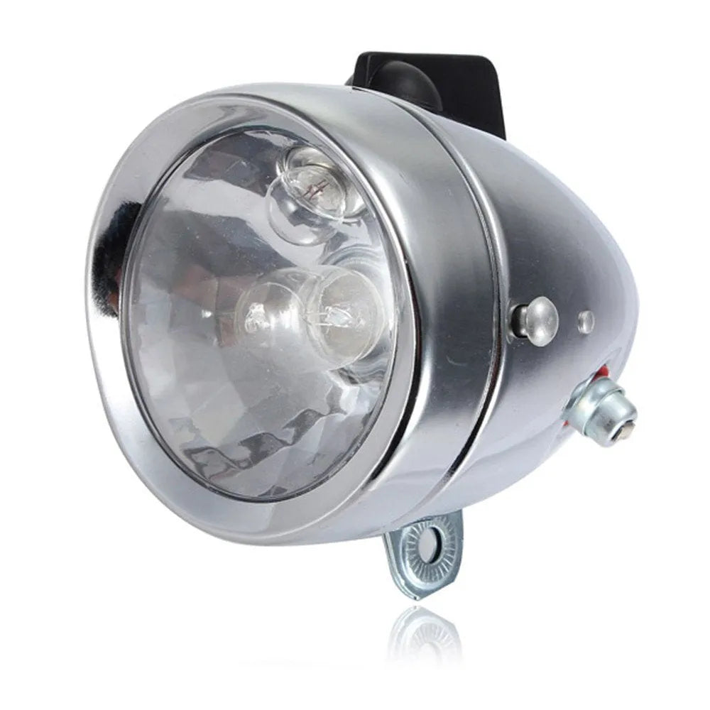 Silver bicycle dynamo generator light kit mounted on a bicycle frame with headlight and taillight.