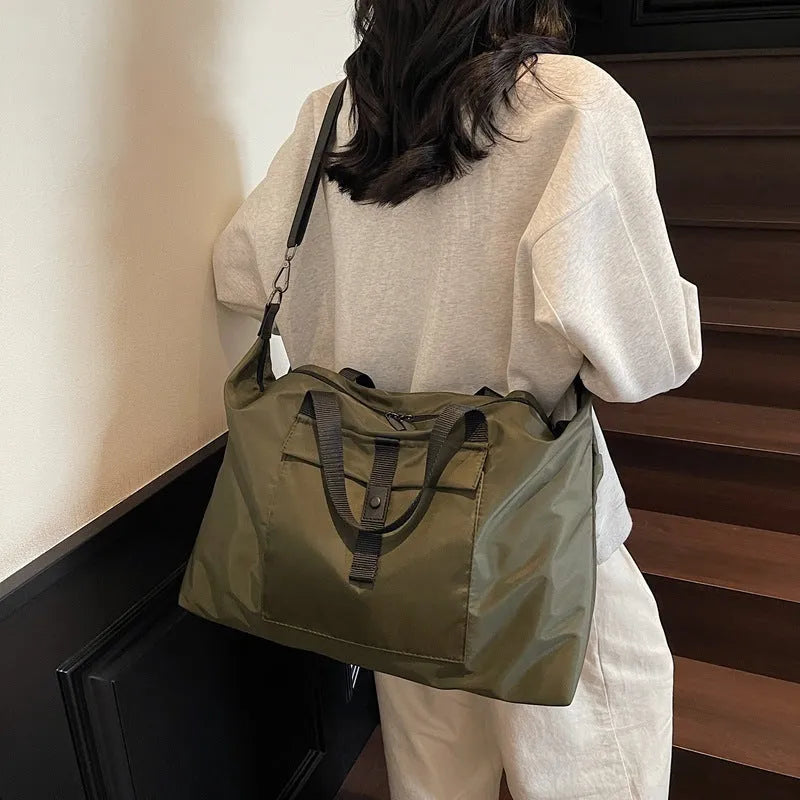 Grey one-shoulder travel bag with 36-55L capacity showing Oxford cloth construction