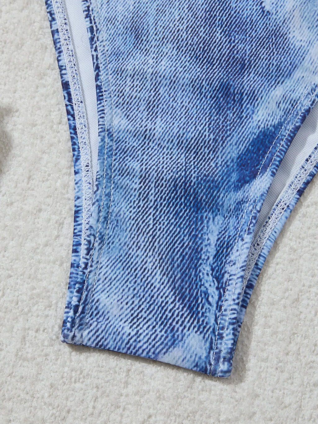 Denim blue printed women's bikini set with strap design on a mannequin, showing top and bottom.