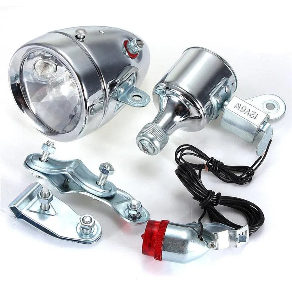Silver bicycle dynamo generator light kit mounted on a bicycle frame with headlight and taillight.